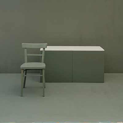 IKEA Besta Kommode mit Türen in Graugrün, Sessel und Rückwand mit NUSSBLAU Farben gestrichen.